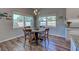 Bright breakfast nook with wood table and chairs, hardwood floors, and large windows at 309 Pavonia Rd, Nokomis, FL 34275