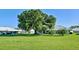 Large backyard with lush grass and mature trees at 3117 Heron Shores Dr, Venice, FL 34293