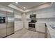 Modern kitchen with white cabinets, stainless steel appliances, and quartz countertops at 3117 Heron Shores Dr, Venice, FL 34293