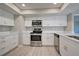 Updated kitchen featuring white cabinetry, stainless steel appliances, and quartz countertops at 3117 Heron Shores Dr, Venice, FL 34293