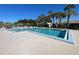 Community pool with lounge chairs and palm trees at 3117 Heron Shores Dr, Venice, FL 34293