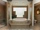 Spa-like bathroom featuring a soaking tub, glass block window, and columns at 315 Park N Blvd, Venice, FL 34285