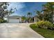 Two-car garage and circular driveway with mature landscaping at 315 Park N Blvd, Venice, FL 34285