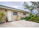 Tan house with a green roof, white garage door, and landscaped yard at 315 Park N Blvd, Venice, FL 34285