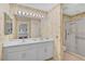 Bathroom with double vanity, shower, and seashell-themed wallpaper at 3730 Cadbury Cir # 300, Venice, FL 34293
