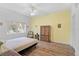 Bright bedroom with a double bed, hardwood floors, and a yellow accent wall at 3730 Cadbury Cir # 300, Venice, FL 34293