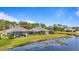 Back view of houses near a lake with screened porches and yards at 3789 Lakewood Blvd, North Port, FL 34287