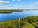 Scenic aerial view of a waterfront property with a private dock on a tranquil blue river under a partly cloudy sky at 38 Riverfront Dr, Venice, FL 34293