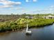 Aerial view of a private dock extending into the river, leading to a home surrounded by lush greenery and trees at 38 Riverfront Dr, Venice, FL 34293