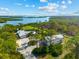 Breathtaking aerial view of a waterfront home with lush landscaping, detached garage, and stunning bay views at 38 Riverfront Dr, Venice, FL 34293