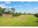 Expansive backyard with lush green grass and tropical foliage, perfect for outdoor activities at 38 Riverfront Dr, Venice, FL 34293