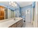 Bathroom with shower, toilet, vanity, and large mirror, and a bright blue color palette at 38 Riverfront Dr, Venice, FL 34293