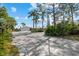 Spacious driveway leading to a well-maintained home featuring mature landscaping and exterior lighting at 38 Riverfront Dr, Venice, FL 34293