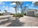 Long driveway leading to a well-maintained home with a two-car garage and a detached garage with mature landscaping at 38 Riverfront Dr, Venice, FL 34293
