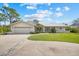 Charming single-story home with a well-manicured lawn, attached two-car garage, and elegant landscaping details at 38 Riverfront Dr, Venice, FL 34293