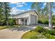 Detached garage featuring an over-sized garage door, covered entryway, and lovely landscaping at 38 Riverfront Dr, Venice, FL 34293