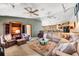 Spacious living room with comfortable seating, bookshelves, ceiling fans, and an open floor plan at 38 Riverfront Dr, Venice, FL 34293