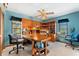 Home office with a large wood desk, built-in shelves, ample lighting, and a ceiling fan at 38 Riverfront Dr, Venice, FL 34293