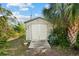 Outdoor storage shed with double doors, a ramp, and lush tropical foliage nearby at 38 Riverfront Dr, Venice, FL 34293