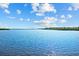 Scenic water view with calm water, green vegetation, and a clear blue sky with scattered clouds at 38 Riverfront Dr, Venice, FL 34293