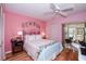 Spacious bedroom with pink walls, queen bed, and access to a patio at 450 Wexford Cir # 106, Venice, FL 34293