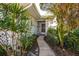 Welcoming walkway leading to the front door, surrounded by tropical plants at 450 Wexford Cir # 106, Venice, FL 34293