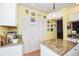 White kitchen cabinets and granite countertops, adjacent to a laundry closet at 450 Wexford Cir # 106, Venice, FL 34293