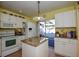 Well-lit kitchen with white cabinets, granite island, and access to patio at 450 Wexford Cir # 106, Venice, FL 34293
