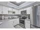 Bright kitchen featuring stainless steel appliances and white cabinetry at 460 Base E Ave # 113, Venice, FL 34285