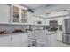 Bright kitchen with white cabinets, granite countertops, and glass-front cabinets at 460 Base E Ave # 113, Venice, FL 34285