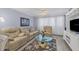 Living room featuring a large sectional sofa and a flat-screen TV at 460 Base E Ave # 113, Venice, FL 34285
