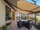 Covered patio with awning, seating, and golf views at 482 Montelluna Dr, North Venice, FL 34275