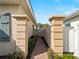 Brick pathway flanked by pillars leads to the front door, with decorative wall art at 482 Montelluna Dr, North Venice, FL 34275