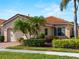 Tan house with tile roof, landscaping, and a two-car garage at 482 Montelluna Dr, North Venice, FL 34275