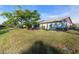 Landscaped backyard with lush lawn and mature trees at 507 Foxwood Blvd # 4, Englewood, FL 34223