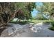 Peaceful patio area with picnic tables under lush trees, near the beach at 5125 Gulf Of Mexico Dr # 7, Longboat Key, FL 34228