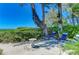 Relaxing patio with lounge chairs and a stone table under shade trees at 5125 Gulf Of Mexico Dr # 7, Longboat Key, FL 34228