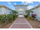 Inviting community pool entrance with lush landscaping and brick pathway at 5747 Sabal Trace Dr # 203B57, North Port, FL 34287