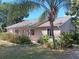 Tan house with landscaped yard and palm tree in partial view, under a clear blue sky at 601 E Seminole Dr, Venice, FL 34293
