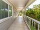 Bright, tiled front porch with white railings and lush green landscaping at 601 E Seminole Dr, Venice, FL 34293
