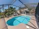 Screened-in pool with clear blue water, surrounded by a spacious deck and lush landscaping at 601 E Seminole Dr, Venice, FL 34293