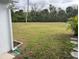 Spacious grassy backyard with mature trees and landscaping at 607 Cervina Dr, Venice, FL 34285