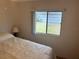 Bedroom featuring a double bed, window with exterior view, and a lamp at 607 Cervina Dr, Venice, FL 34285