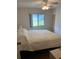 Spacious bedroom with a large bed, ceiling fan, and window with backyard view at 607 Cervina Dr, Venice, FL 34285