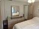 Bedroom with a dresser, large mirror, and view into another bedroom at 607 Cervina Dr, Venice, FL 34285