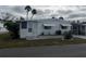 White single-wide manufactured home with carport and landscaping at 607 Cervina Dr, Venice, FL 34285