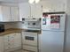 View of kitchen with white cabinets, wood laminate countertops, and electric stove at 607 Cervina Dr, Venice, FL 34285