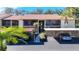 Condo building with carport parking, tropical landscaping, and screened-in lanais on each unit at 654 Bird Bay E Dr # 206, Venice, FL 34285