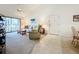 Open-concept living space features a slider to the lanai, comfortable seating, and seamless flooring at 654 Bird Bay E Dr # 206, Venice, FL 34285