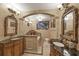 Elegant bathroom with double vanities, a large soaking tub, and ornate mirrors at 690 Percheron, Nokomis, FL 34275